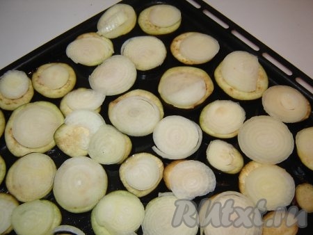 Затем на каждый кусочек баклажана положить кружок лука.