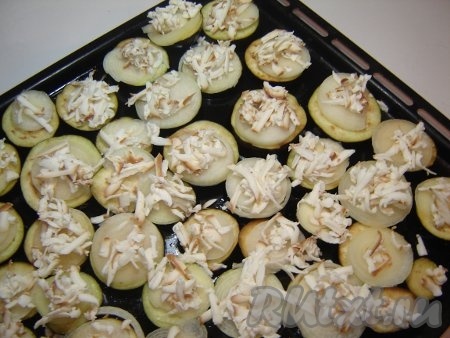 На каждый кружок из овощей положить сыр, натёртый на крупной тёрке.