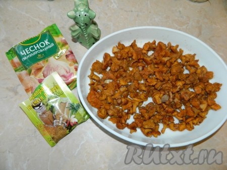 Отваренные лисички выложить тонким ровным слоем в смазанную маслом форму. Посыпать чесноком, перцем, солью.
