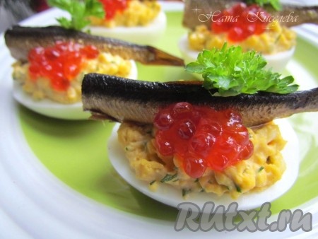 Закуска из фаршированных яиц со шпротами и красной икрой получилась очень вкусной, аппетитной, она очень удачно вписалась в праздничное меню.