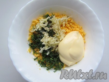 В тарелку с желтками добавить чеснок, укроп, майонез, щепотку чёрного молотого перца, тщательно перемешать. Если нужно, подсолить по вкусу.