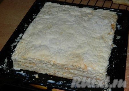 Обрезаем края торта. Пропитанный торт хорошо режется. А главное, что эти обрезки можно сразу попробовать, не дожидаясь праздника. Затем кремом, который мы оставляли, обмазываем все края и верх торта. Измельчаем оставленный корж и обсыпаем торт со всех сторон. Измельчать корж удобно, сложив поломанный корж в пакет и прокатав по пакету скалкой.