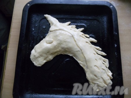 Из теста вырезать гриву, красиво украсить и смазать яйцом, слегка взбитым вилочкой (яйцо поможет пирогу приобрести золотистую корочку).
