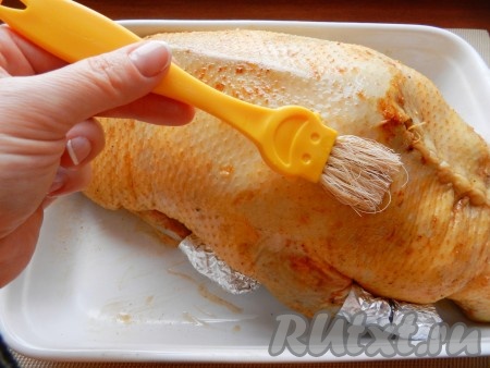 Утку наполнить начинкой, плотно  зашить отверстие белыми нитками, кончики крылышек и ножек обернуть фольгой. Положить утку на противень или в форму для запекания. Смешать мед и ром в одинаковой пропорции и этой смесью смазать поверхность утки. Запекать новогоднюю утку в разогретой до 180 градусов духовке в течение двух часов. В процессе запекания смазывать смесью рома и мёда и поливать жиром, который вытекает при запекании.