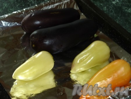 Противень для запекания выстелить фольгой. Баклажаны и болгарские перцы вымыть. Выложить овощи на противень и запекать в разогретой духовке при температуре 180 градусов до готовности (в течение 30-35, овощи должны стать достаточно мягкими, они должны легко прокалываться вилкой).
