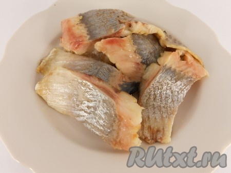 Филе слабосолёной сельди осмотреть, удаляя косточки. Нарезать селёдку на части.