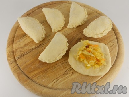 Тесто скатать колбаской и нарезать небольшими кусочками. Каждый кусочек раскатать в лепешку. Поместить в центр по 1 чайной ложке квашеной капусты, слепить вареник. Таким образом подготовить все вареники.
