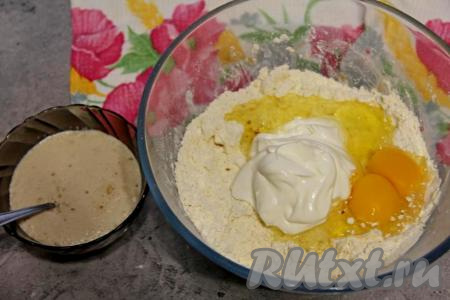 Перетереть руками кусочки масла и муку в крошку. Затем в миску вбить сырые яйца и добавить сметану.