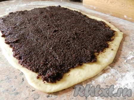 Равномерно распределить маковую начинку и свернуть пласт теста рулетом.