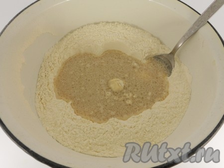 В большую миску просеять муку, сделать углубление и влить дрожжевую смесь.