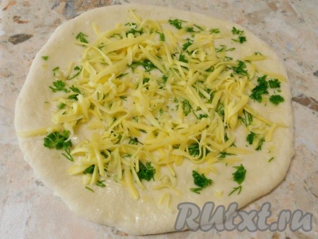 Каждую часть раскатать в небольшую лепешку. Смазать масляно-чесночной смесью и посыпать сыром.