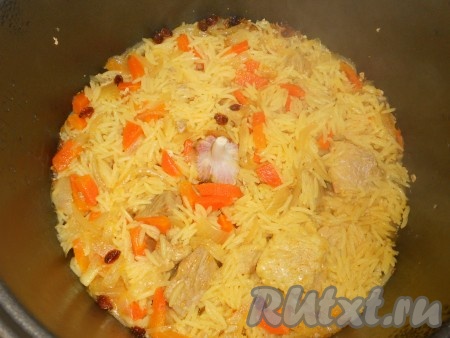 Закрыть крышку мультиварки, выставить режим "Рис", "Плов" или "Тушение" минут на 30-35. Через 10 минут от начала готовки, крышку открыть и в центр поместить головку чеснока, очищенную от верхней шелухи.
