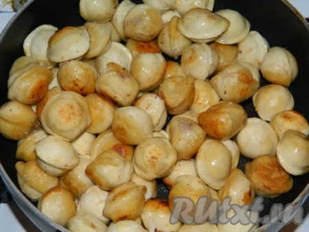 В сковороде разогреваем растительное масло, выкладываем замороженные пельмени и обжариваем их до румяного цвета со всех сторон, периодически перемешивания. Благодаря предварительному обжариванию, пельмени не слипнутся в процессе запекания.