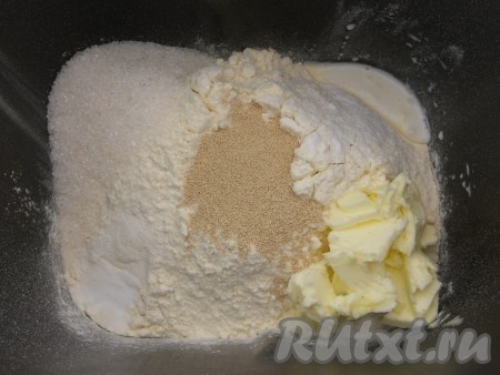 Добавить размягченное сливочное масло, а в углубление посередине всыпать дрожжи.