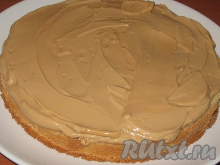 Выложить половину крема и равномерно распределить.
