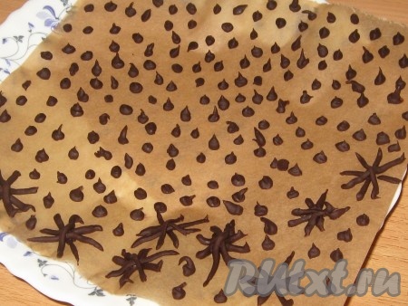 Шоколад поломать на кусочки, добавить 1 столовую ложку воды и расплавить на водяной бане или в микроволновке, затем переложить в уголок полиэтиленового пакета, прорезать маленькое отверстие и на пергамент выложить капли шоколада (можно сделать несколько снежинок), убрать в морозильную камеру до застывания.
