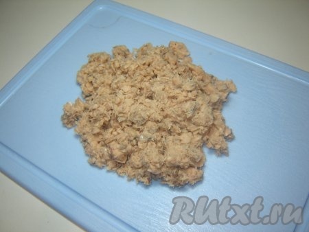 Откройте банку консервированной горбуши, слейте жидкость и разомните консервы.