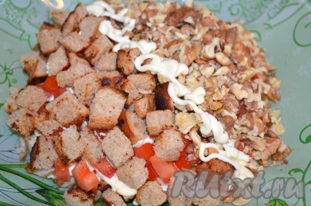 Сверху выложить сухарики, орехи и зелень. Перед подачей перемешать.&nbsp;