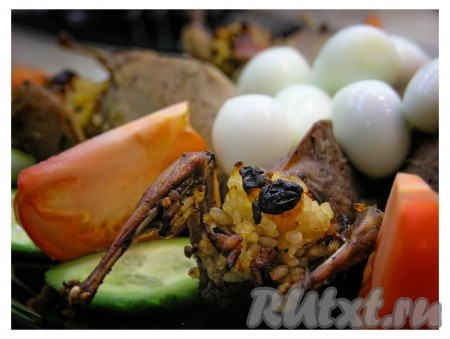 Перепелок, фаршированных рисом, сухофруктами и апельсинами, украсить яйцами и овощами. 