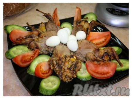 Перепелок, фаршированных рисом, сухофруктами и апельсинами, украсить яйцами и овощами. 