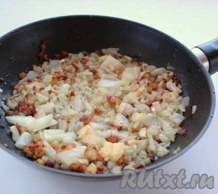 Обжарить срезанный с рёбер жир в течение 1-2 минут на сковороде, затем выложить нарезанный лук и обжарить его на среднем огне до прозрачности, не забывая помешивать.