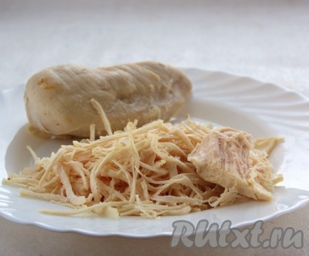 Вареное куриное филе разделать на волокна.