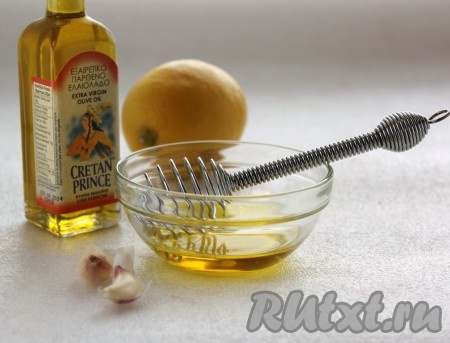 Приготовить заправку для салата из куриной грудки и овощей. Измельчить чеснок и добавить его в смесь оливкового масла и лимонного сока, размешать.
