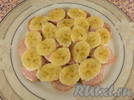 Половинки пряников окунать в сметанную смесь и выкладывать на плоскую тарелку по кругу слоями. Вначале выложить первый слой пряников, немного полить сметанной смесью, выложить тонко нарезанные кружочки банана.&nbsp;