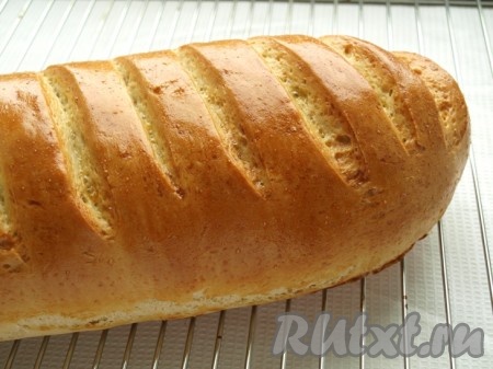 В духовке, разогретой до 180 градусов, выпекаем батон 30 минут. Готовый батон выкладываем на решётку, накрываем полотенцем и даём остыть.
