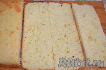 Срезать верхушку и раскрошить ее. Разрезать бисквит на 2 коржа. Затем на 3 полоски поперек.