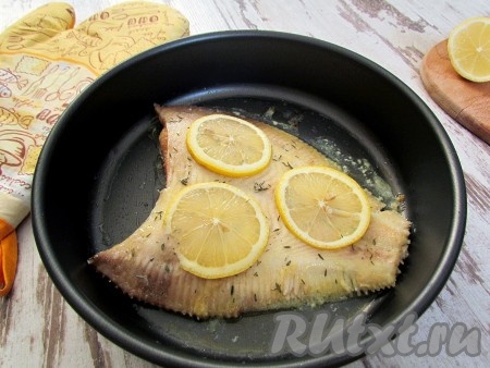 Камбалу выньте из духовки, посыпьте сушеным тимьяном, сбрызните лимонным соком, положите сверху ломтики лимона и еще три-четыре кусочка сливочного масла и запекайте около 10 минут.
