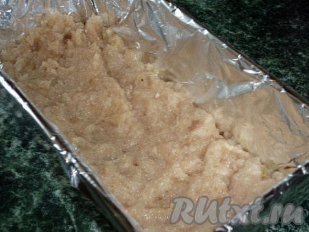 Прямоугольную форму застелить фольгой и выложить половину фарша.