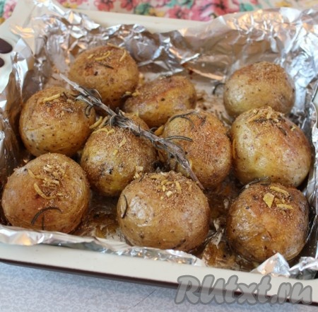 Картофель достать из духовки, посыпать ароматными специями. Специи выбирайте по вкусу, я использовала веточку розмарина и молотый кориандр. Можно готовить без специй, тоже получится вкусно.