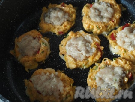 Куриное филе перекручиваем на мясорубке с добавлением второй половины луковицы. На сковороду с разогретым растительным маслом ложкой выкладываем овощную смесь, в центр помещаем немного фарша, придавливая ложкой. Обжариваем оладьи с двух сторон до золотистой корочки.
