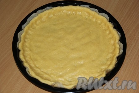 Форму для выпекания застелить пергаментной бумагой. Выложить тесто в форму и сформировать бортик.