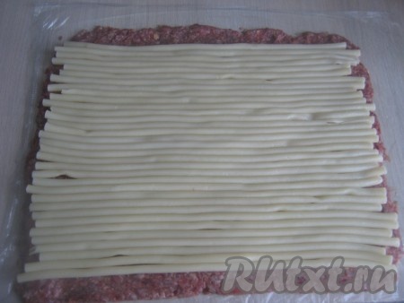 Выкладываем макароны одним слоем, оставляя нижний и верхний край на 2 см без макарон. Это нужно для того, чтобы после сворачивания макароны не были видны по краям рулета, а в середине был красивый рисунок из макарон.
