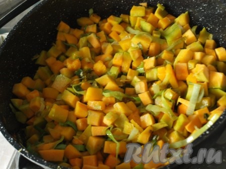 Тыкву очистить. 700 грамм очищенной тыквы нарезать на некрупные кубики. Лук-порей нарезать кольцами. В сковороде разогреть оливковое масло, выложить тыкву и лук-порей, обжарить их на среднем огне, помешивая, в течение 5-6 минут.