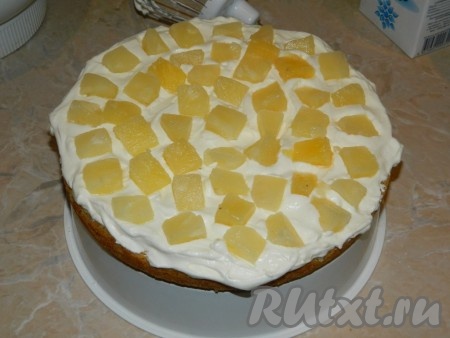 Смазываем обильно первый корж кремом и выкладываем кусочки ананасов.