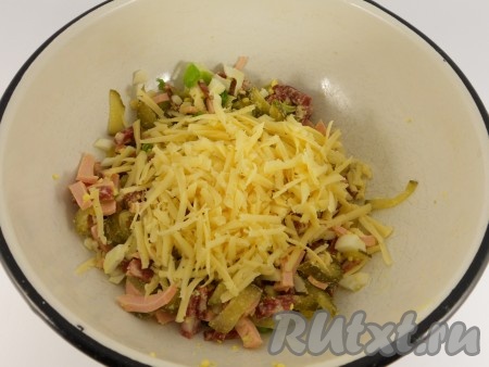 Сыр натереть на крупной терке. Половину сыра добавить в салат.