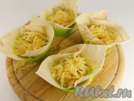 Поместить квадратики в формочки для кексов (получатся корзиночки). Начинить их подготовленным салатом, а сверху посыпать оставшимся сыром.