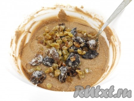 Чернослив нарезать на 2-3 части и присыпать немного мукой, перемешать. Добавить нарезанный чернослив и изюм в тесто, хорошо перемешать ложкой.