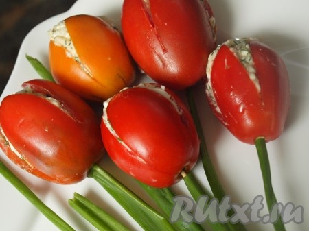 В основание помидора вставляем зубочистку, на которую надеваем стебель зелёного лука. Аналогично делаем "стебельки" и у остальных наших тюльпанчиков.