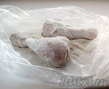 Кладём в пакет с мукой куриные ножки, хорошо встряхиваем, чтобы мука равномерно обволокла мясо.