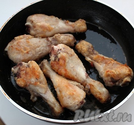 Сковороду разогреваем с растительным маслом. Выкладываем куриные ножки и обжариваем со всех сторон до румянца (в течение 4-5 минут) на среднем огне. После того как мясо покроется со всех сторон румяной корочкой, вливаем в сковороду 100 миллилитров воды, доводим её до кипения, делаем огонь минимальным и протушиваем мясо под крышкой в течение 15-20 минут.