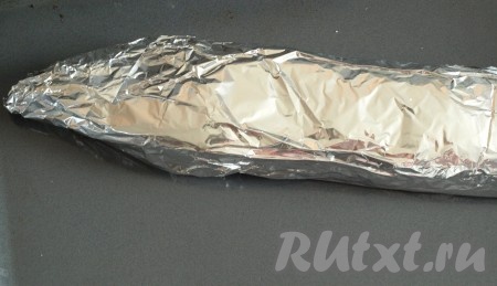 Достаём шкуру щуки из холодильника и наполняем её не очень туго приготовленным фаршем. Выкладываем фаршированную щуку на фольгу, прикладываем голову и смазываем рыбу майонезом. Щуку плотно заворачиваем в фольгу и ставим в духовку, разогретую до 180 градусов, на 1 час.
