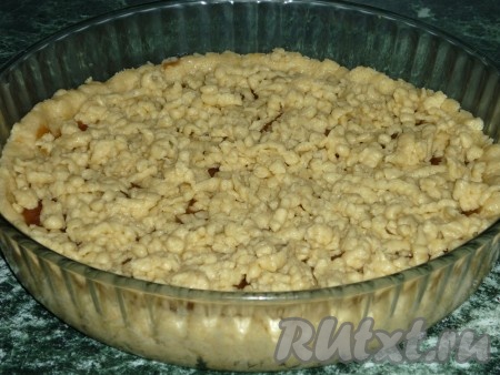 Достаём часть теста из морозилки и натираем его на крупной тёрке поверх варенья, равномерно покрывая пирог.