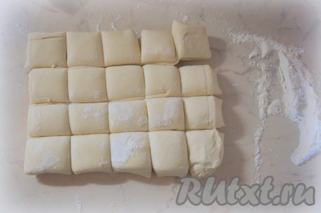 Слоёное тесто можно взять и дрожжевое, и бездрожжевое. Тесто разморозить при комнатной температуре. Рабочую поверхность присыпать мукой. Тесто раскатать до толщины 4-5 миллиметров, разрезать на небольшие квадраты одинакового размера (с размером стороны примерно 5 сантиметров).