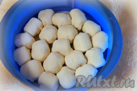 Духовку разогреть до 180 градусов. Форму для выпечки смазать растительным маслом. Плотно друг к другу швом вниз выложить сформированные булочки из слоёного теста с сосиской внутри.