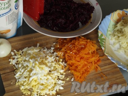 Сваренные картошку, морковку, свёклу, яйца очищаем и натираем их по отдельности на крупной тёрке. Лук режем кубиком, ошпариваем кипятком, чтобы удалить горечь, а затем сразу промываем холодной водой.
