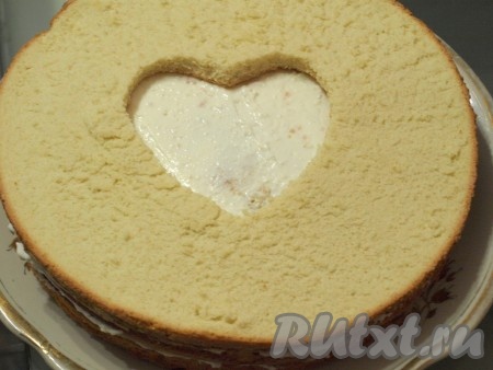 Кладём третий корж с вырезанным сердечком, пропитываем его, смазываем кремом, осталось положить четвертый корж с сердцем, пропитать его. Тщательно смазываем торт, в том числе и сердечко, кремом.
